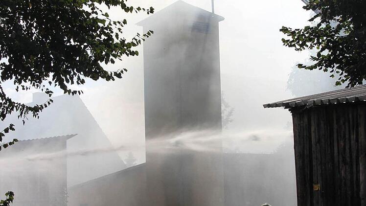 Der Brandherd liegt neben dem alten Feuerwehrhaus und dem Schlauchtrockenturm in Au.  Foto: Friedwald Schedel