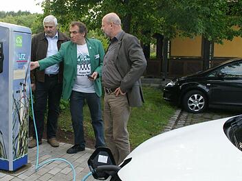 Einer der Ersten mit Elektromobil war Hans Josef Fell aus Mellrichstadt einst. Heute genießt er den Komfort eines hochmodernen Elektroautos und von Stromtankstellen wie in Oberschleichach, wo er während seiner Buchvorstellung sein Auto wieder auflud. Mit dabei: Energieberater Günther Lieberth und Oberaurachs 2. Bürgermeister Hans Albert. Fotos: Sabine Weinbeer