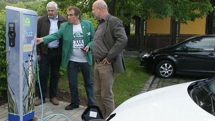 Einer der Ersten mit Elektromobil war Hans Josef Fell aus Mellrichstadt einst. Heute genießt er den Komfort eines hochmodernen Elektroautos und von Stromtankstellen wie in Oberschleichach, wo er während seiner Buchvorstellung sein Auto wieder auflud. Mit dabei: Energieberater Günther Lieberth und Oberaurachs 2. Bürgermeister Hans Albert. Fotos: Sabine Weinbeer