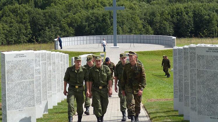 Deutsche und russische Soldaten arbeiten gemeinsam auf dem Friedhof Duchowschtschina bei Smolensk.