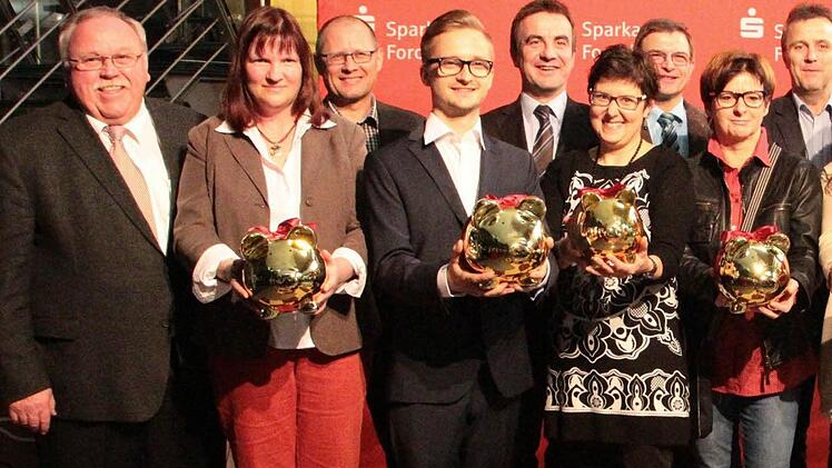 Flankiert von Sparkassenchef Ewald Meier (r.) und Bürgermeister Franz Streit (l.) erhielten die Vertreter der oben stehenden Einrichtungen mit Fördermitteln gefüllte Sparschweinchen.  Foto: Josef Hofbauer