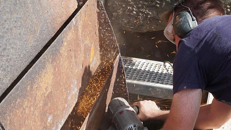 Stefan Leitsch durchschneidet das Mühlrad mit der Flex. Foto: Marion Eckert