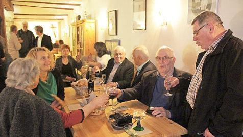 Zahlreiche G&auml;ste sto&szlig;en auf eine gute Zukunft der Weinstube an.
