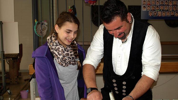 Interessiert schaut Marina Schütz Mario Ströhlein von der Dachdeckerei Neubauer-Ströhlein über die Schulter. Foto: Susanne Deuerling