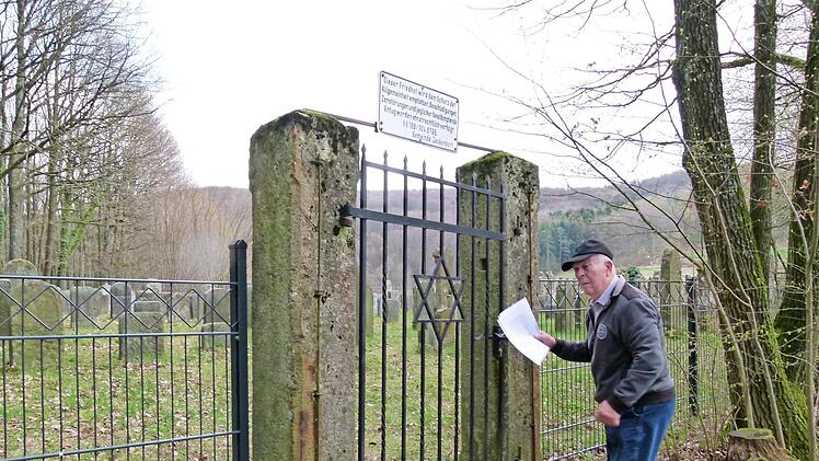 Georg Baumann schließt das Tor zum Friedhof der Demmelsdorfer und Zeckendorfer Juden auf.