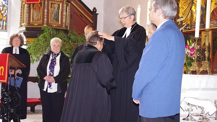 Dekanin Dorothea Richter (3. v.r.) führte Pfarrer Michael Foltin in sein neues Amt ein. Foto: Heike Schülein