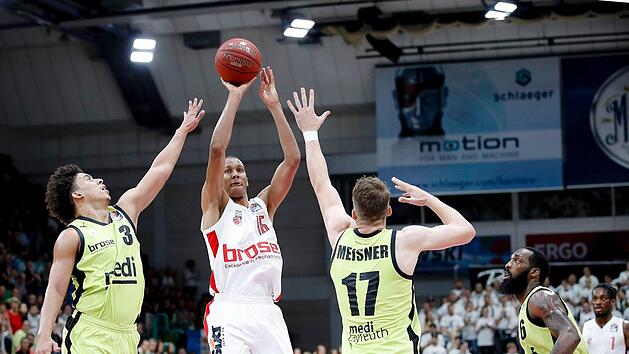 Immer mehr zum Leistungstr&auml;ger im Bamberger Spiel avanciert Louis Olinde, der hier zum Wurf gegen die Bayreuther James Robinson (links) und den im letzten Viertel starken Lukas Meisner kommt. Daniel L&ouml;b