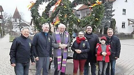Nach dem Aufstellen der Osterkrone auf dem Quellstein(v.l.): Dritter Vorsitzender Albin Fischer, Zweiter Vorsitzender Uwe Bobreck, Parrer i. R. Baptist Schaffer, Vorsitzende Jutta Dietzel, Stadtrat Michael Zwingmann, Bürgermeister Wolfgang Beiergrößlein mit Sohn Jannik.  Foto: Gerd Fleischmann