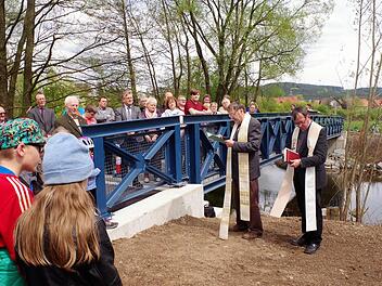 Der 23 Meter breite Engelessteg ist über den Haßlachfluss durch die beiden Geistlichen Hans-Michael Dinkel und Michael Foltin eingeweiht worden. Mit im Bild auch Bürgermeister Rainer Detsch. Im Hintergrund ist Reitsch sichtbar. Foto: Gerd Fleischmann