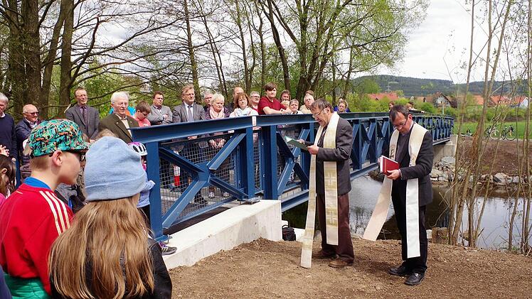 Der 23 Meter breite Engelessteg ist über den Haßlachfluss durch die beiden Geistlichen Hans-Michael Dinkel und Michael Foltin eingeweiht worden. Mit im Bild auch Bürgermeister Rainer Detsch. Im Hintergrund ist Reitsch sichtbar. Foto: Gerd Fleischmann