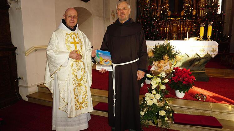 Pater Georg Andlinger (l.) übergab den Erlös des Adventsmarktes an Pater Alfons Schumacher (rechts), den Leiter der Franziskaner-Mission.  Foto: Marion Eckert