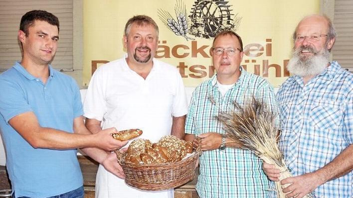 Aus Sondernauer und Weisbacher Urgetreide wird in Bischofsheim Ackerritterbrot und Urspitz. Die drei Landwirte Michael Tulit (links), Peter Friedrich (zweiter von recht) und Rudolf Wappes (rechts) bauen die Urgetreide Emmer, Waldstaudenroggen und Dinkel an. Bäckermeister Manfred Enders von der Degetsmühle hat nach längerem Tüfteln die beiden Vollkornprodukt kreiert.  Foto: Marion Eckert