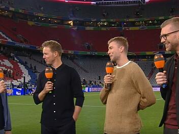 Im ersten Halbfinale des "Final Four"-Turniers der UEFA Nations League 2025 trifft Gastgeber Deutschland in München auf Portugal. Moderator Jochen Breyer (links) und seine Experten Christoph Kramer (zweiter von rechts) und Per Mertesacker (rechts) werden das Spiel wohl hinterher mit Trainer Julian Nagelsmann analysieren.