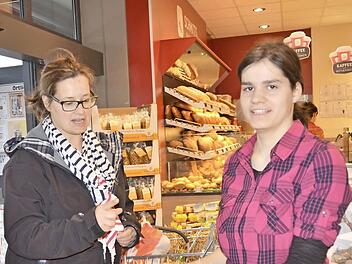 Bei den mundgerechten Apfelstückchen greift Kundin Sandra Schlereth (links) gerne zu. Gereicht werden sie von Carina Gundelach, die Auszubildende im Rhöncenter Burkardroth ist und erst vor Kurzem bei der Apfelernte dabei war. Foto: Kathrin Kupka-Hahn