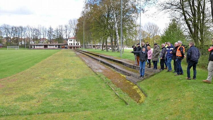 Der Bausenat besichtigt die Freisportanlage. Wo früher die Laufbahn war, ist gerade noch so zu erkennen. Sie soll normgerecht neu erstellt werden, der Fußballplatz soll einen Kunstrasen bekommen. Foto: Rainer Lutz