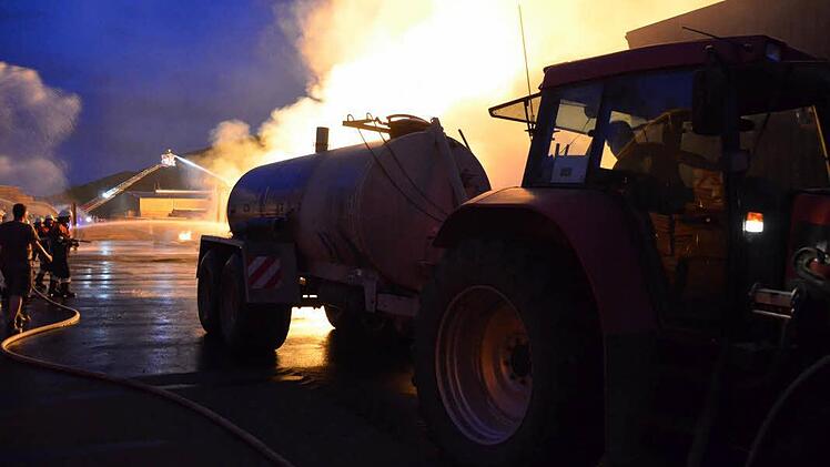 Landwirte brachten Gülletanks voll Wasser. Um nah an die Flammen fahren zu können, musste die Feuerwehr die Reifen der Traktoren abspritzen. Foto: Rauch