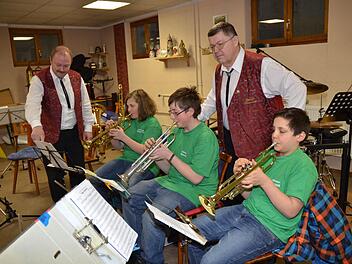 Sie fiebern dem 100. Jubiläum des Musikvereins Tettau entgegen. Dirigent Holger Heinz (links) und Vorsitzender Dietmar Schmidt (rechts, stehend) mit den 13-jährigen Nachwuchstalenten (von links) Max Neubauer, Nico Krauss und Valentin Ruß. Foto: K.-H. Hofmann