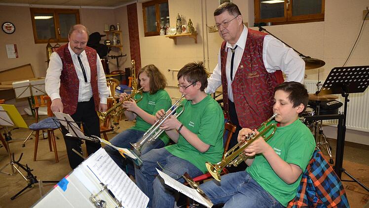 Sie fiebern dem 100. Jubiläum des Musikvereins Tettau entgegen. Dirigent Holger Heinz (links) und Vorsitzender Dietmar Schmidt (rechts, stehend) mit den 13-jährigen Nachwuchstalenten (von links) Max Neubauer, Nico Krauss und Valentin Ruß. Foto: K.-H. Hofmann