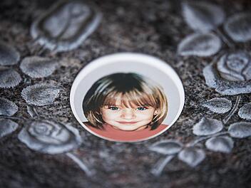 Was geschah mit der kleinen Peggy? Ein Foto auf einem Gedenkstein auf dem Nordhalbener Friedhof erinnert an die im Mai 2001 verschwundene Schülerin aus dem oberfränkischen Lichtenberg.  Foto: David Ebener/dpa