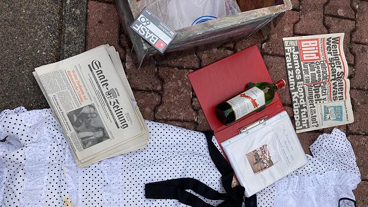 Ein Festkleid der Damen, zwei Flaschen Schnaps, Saale-Zeitung, Mainpost und Bildzeitung mit entsprechenden Meldungen, eine Kassette und eine Mappe mit Informationen befanden sich in der Kiste.