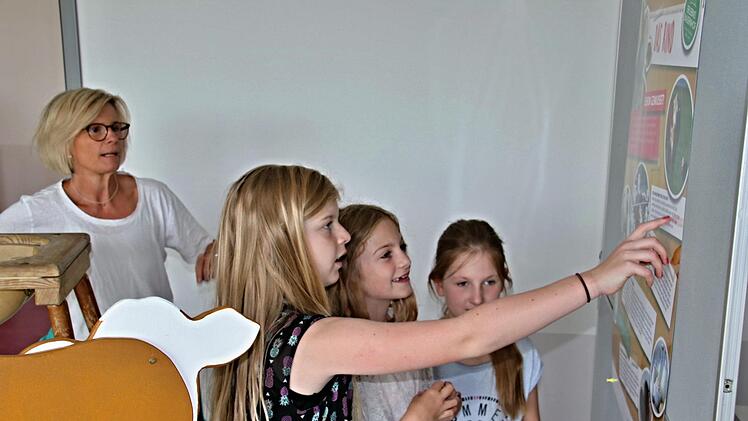 Informationen rund um die Kuh. Klassenleiterin Alexandra Wachter-Spies mit drei ihrer Schülerinnen an der Infotafel. Foto: Helmut Will