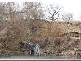 Georg Hötzelein, Erich Bauernschmitt und Hans Kist stehen vor dem eingestürzten Bogen (Steinhaufen), dahinter lässt sich noch mit dem erkennbaren Bogen die Burg erahnen. Foto: Franz Galster