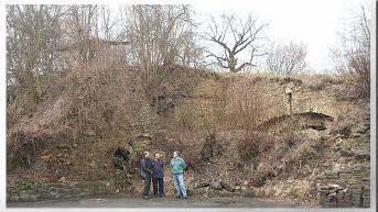 Georg Hötzelein, Erich Bauernschmitt und Hans Kist stehen vor dem eingestürzten Bogen (Steinhaufen), dahinter lässt sich noch mit dem erkennbaren Bogen die Burg erahnen. Foto: Franz Galster
