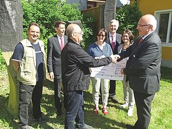 Am künftigen Endpunkt des "Nordhalbener Skulpturenwegs" am Künstlerhaus übergab Geschäftsstellenleiter Alfred Rosenbaum (rechts) an NohA-Sprecher Otmar Adler (Dritter von links) einen Scheck in Höhe von 3000 Euro für weitere Exponate.  Foto: Norbert Neugebauer