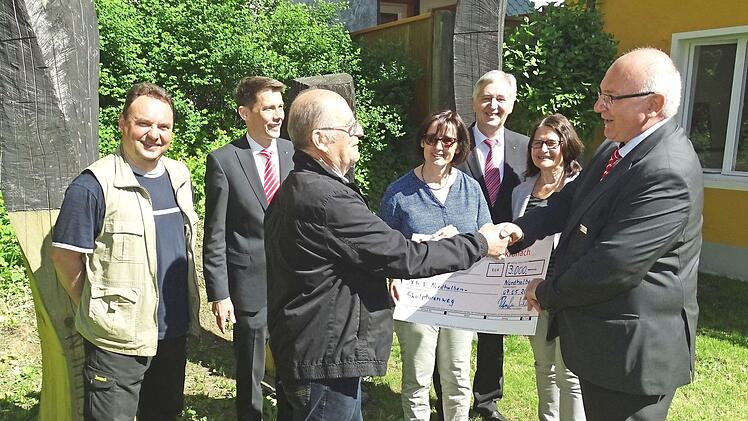 Am künftigen Endpunkt des "Nordhalbener Skulpturenwegs" am Künstlerhaus übergab Geschäftsstellenleiter Alfred Rosenbaum (rechts) an NohA-Sprecher Otmar Adler (Dritter von links) einen Scheck in Höhe von 3000 Euro für weitere Exponate.  Foto: Norbert Neugebauer