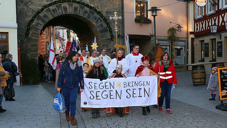 Die Sternsinger ziehen durch das untere Tor in Lichtenfels in Richtung Rathaus.