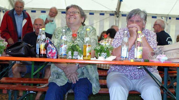 Sieglinde Fischer (links) und Christa Franz haben einen Weg gefunden, um sich vor nassen Füßen im Zelt zu schützen.