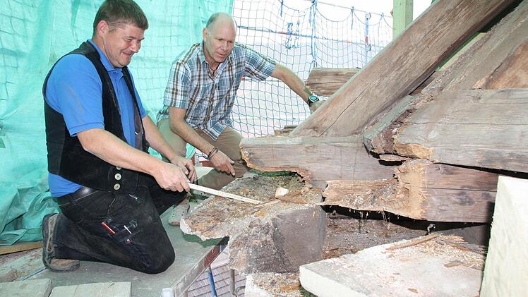 Zimmerer Marko Fischer (von links) und Architekt Henry Kiesel mussten im zurückliegenden Jahr immer wieder Schäden am Gesims und an Knotenpunkten der Dach-Konstruktion begutachten.  Fotos: Ralf Ruppert
