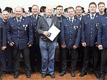 Ludwig Dück (mit Urkunde) im Kreis seiner Feuerwehrkameraden mit Stadtkommandant Christian Kunstmann (2. v. l.), dem Wohnsiger Kommandanten Georg Tempel (4. v. l.), Kreisbrandmeister Matthias Müller (5. v. l.) und Kreisbrandinspektor Thilo Kraus (...