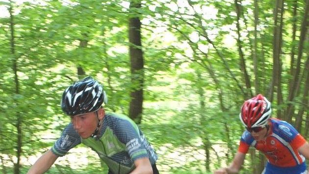 Zwei Fahrer der Altersklasse U17 fahren hier auf einen ansteigenden matschigen Waldweg. Foto: Alfred Thiert