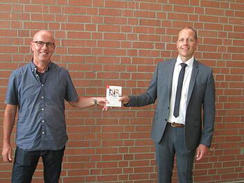Günter Betzen (links) ist gewählter Ortssprecher von Trimberg. Bürgermeister Johannes Krumm (rechts) gratulierte und übergab das "Handbuch für Gemeinderäte".            Foto: Winfried Ehling