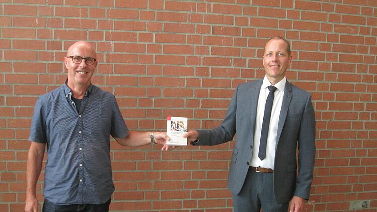 Günter Betzen (links) ist gewählter Ortssprecher von Trimberg. Bürgermeister Johannes Krumm (rechts) gratulierte und übergab das "Handbuch für Gemeinderäte".            Foto: Winfried Ehling