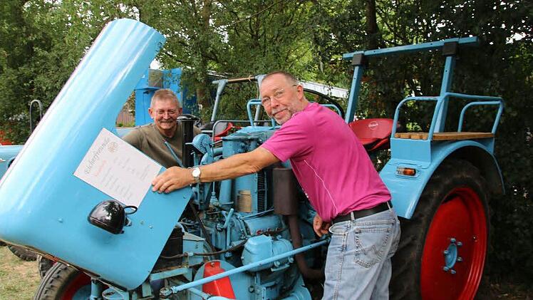 Interessiert schauen Siegfried Ahles (rechts) und Manfred Banaschik (links) aus Ützing (Landkreis Lichtenfels) sich den Eicher von Thomas Billinger aus dem Jahr 1955 an. Banaschik richtet sich gerade auch einen Eicher her. "Diese alte Technik finden wir ja heutzutage gar nicht mehr", meint er. Foto: Bettina Knauth