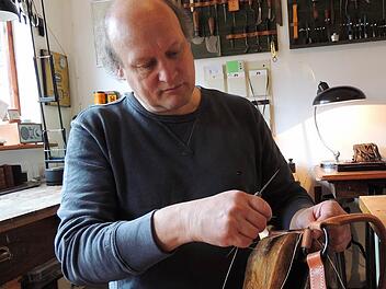 Auf einem speziellen Schemel näht Joachim Buhl Gürtel, Jagdtaschen und Halfter per Hand. Fotos: Birgitta Müller/