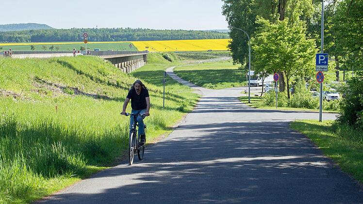 Im Herbst beginnen die Arbeiten für die Umfahrung der Mainflutbrücke in Haßfurt (hinten links im Bild), damit die Brücke in den kommenden zwei Jahren saniert werden kann. Für die Bauzeit von zwei, drei Jahren wird eine Umfahrungsstraße durch das Tal (im Bild) angelegt, die über die Zufahrt zum FC von Haßfurt geführt wird; der Radweg soll erhalten bleiben. Fotos: Ulrike Langer