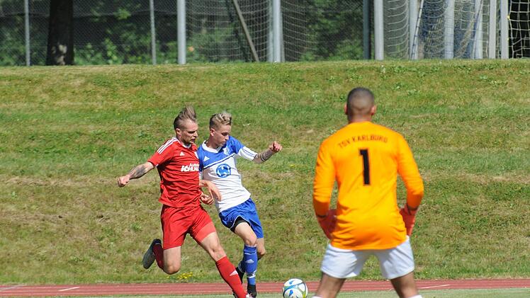 Marvin Schramm vom TSV Karlburg bearbeitet im Testspiel den Bad Kissinger Torschützen Nils Halbig; Karlburgs Keeper Marvin Fischer-Vallecilla beobachtet das Ganze. Am Ende verlor der FC 06, schlug sich aber achtbar. Foto: ssp