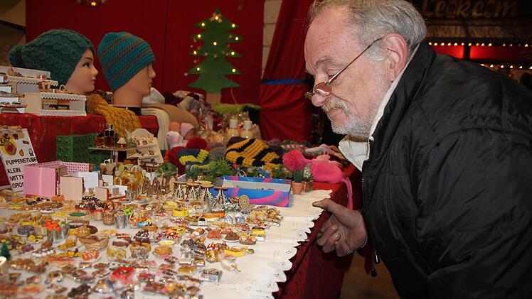 Winfried Fritsch bewundert die Puppenstubenminiaturen, die aussehen als stammten sie aus einer Konditorei. Sie sind aber nur aus Knetmasse geformt.  Foto: Stephan Stöckel