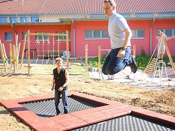 Der neue Spielplatz an der Gerold-Strobel-Halle in Bad Rodach kommt voran. Während im Hintergrund die Bauarbeiten weiter gingen, testeten Heike Habermaass (links) und Bürgermeister Tobias Ehrlicher am Montag schon einmal die bereits eingebauten zwei mal zwei Meter großen Boden-Trampoline. Foto: Bettina Knauth