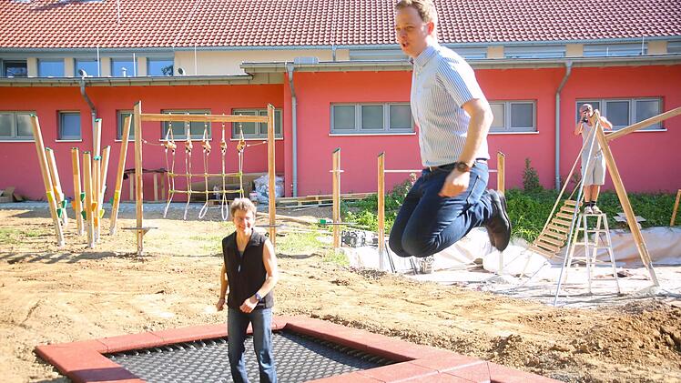 Der neue Spielplatz an der Gerold-Strobel-Halle in Bad Rodach kommt voran. Während im Hintergrund die Bauarbeiten weiter gingen, testeten Heike Habermaass (links) und Bürgermeister Tobias Ehrlicher am Montag schon einmal die bereits eingebauten zwei mal zwei Meter großen Boden-Trampoline. Foto: Bettina Knauth