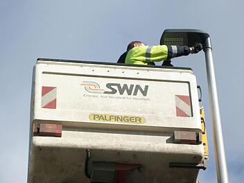 Ein Mitarbeiter der Neustadter Stadtwerke tauscht eine alte Quecksilberdampflampe gegen eine LED-Leuchte aus. Foto: Konrad Sünkel
