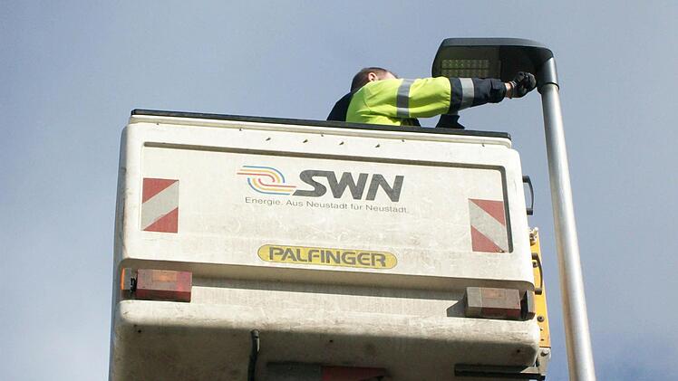 Ein Mitarbeiter der Neustadter Stadtwerke tauscht eine alte Quecksilberdampflampe gegen eine LED-Leuchte aus. Foto: Konrad Sünkel