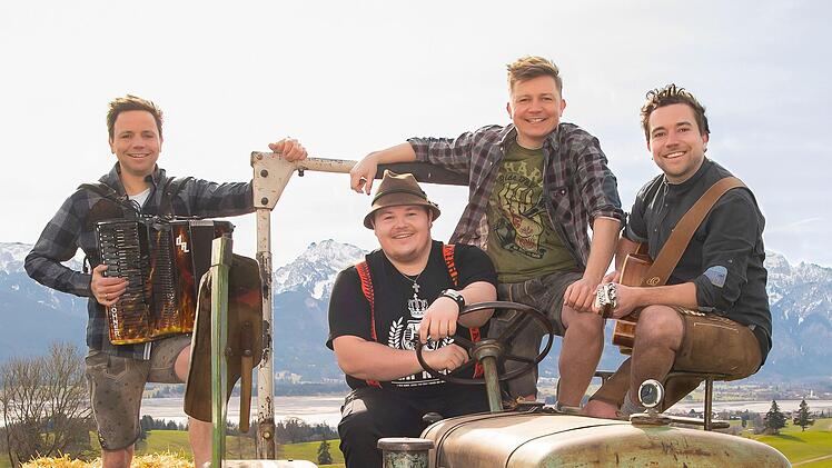 Die "Dorfrocker" Markus, Tobias und Philipp Thomann (von links) hier mit dem Comedian Thomas Willibald ("Addnfahrer"), der am Steuer sitzt, sind bald in Maßbach, um dort zwei Konzerte zu geben. Foto: Christian Pöhlmann
