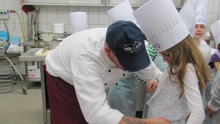 Zum Schutz gibt es erstmal Kochmützen und Plastikschürzen.