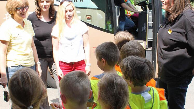 Schön in einer Reihe vor dem Bus aufgestellt - das bringt Sicherheit beim Busfahren. Die Erstklässler der Lehrerin Elke Schnitzer (links) beherzigen die Regel, die ihnen Dagmar Mayer (rechts) beigebracht hat. Die beiden Mütter Simone Zährl und Diana Brandl (weiter von links) beobachten die Szene. Im Bus zeigt der Fahrer Karl Burger der kleinen Lena und dem kleinen Leon, wie man sich am Steuer fühlt.  Foto: Klaus Schmitt