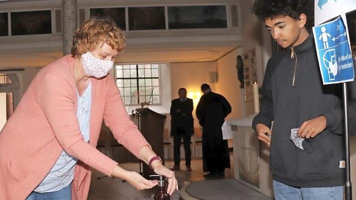 Sabine Kretschmar tr&auml;gt zum Gottesdienst in der evangelischen Spitalkirche vorschriftsm&auml;&szlig;ig eine Maske und desinfiziert sich die H&auml;nde. Mesner Bruck Br&uuml;ckner (rechts) hat ein Auge darauf, dass alle Auflagen eingehalten werden.  Foto: Katrin Geyer