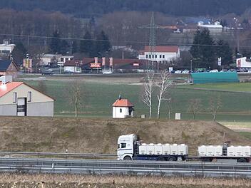 Etwa fünf Meter überragt die Oberkante des Lärmschutzwalls die Fahrbahn. Somit verschwinden Lastwagen dahinter. Die Bewohner Ebensfelds werden somit großenteils von dem Verkehrslärm verschont. Foto: Matthias Einwag